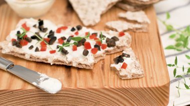 Peynirli aperatif tost, kırmızı dolma biber, zeytin ve ahşap masada kekik. Sağlıklı gıda, vegan ya da diyet beslenme konsepti.