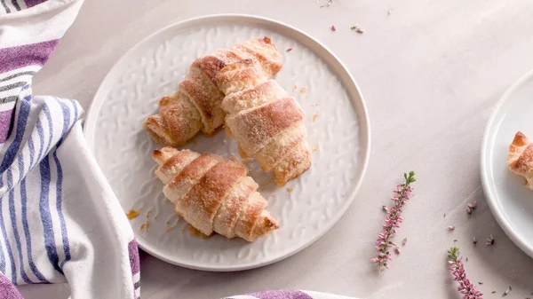 Pienet Croissantit Valkoisilla Keraamisilla Levyillä Kotitekoisia Kakkuja Betonipöydällä — kuvapankkivalokuva