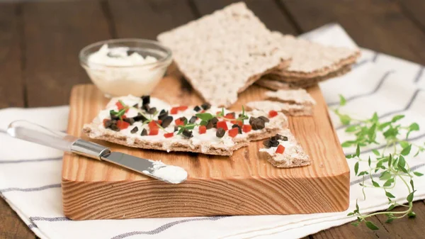 Peynirli aperatif tost, kırmızı dolma biber, zeytin ve ahşap masada kekik. Sağlıklı gıda, vegan ya da diyet beslenme konsepti.