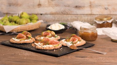 Kanepe veya crostini ile krem peynir ve incir ile tahıllı crispread jam kayrak bir gemide. Lezzetli meze bir aperatif ideal.