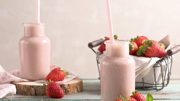 健康草莓奶昔在梅森玻璃罐子与散落的水果在一个质朴的木材背景 — 图库照片