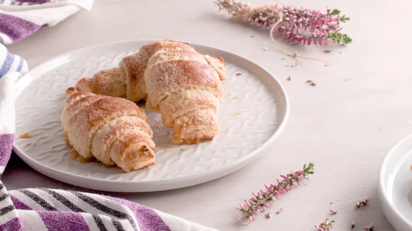 Pienet Croissantit Valkoisilla Keraamisilla Levyillä Kotitekoisia Kakkuja Betonipöydällä — kuvapankkivalokuva