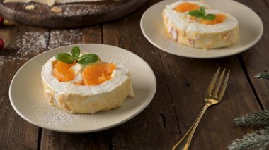 Kremalı ve mandalinalı kremalı kek. Roulade, seramik tabakta servis edilen yaz tatlısı..