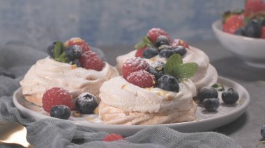 Taze ahududu ve yaban mersini ile küçük pavlova kek.