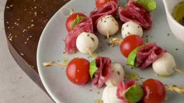 İtalyan usulü aperatif, antipasto şiş ya da fesleğen, salam, mozarella ve domatesli bir çubukta caprese..