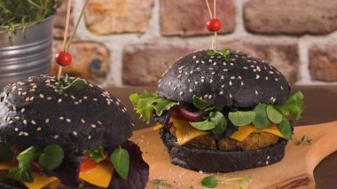 Lezzetli ızgara vejetaryen burger, mercimek, kuru domates ve ahşap tezgahta siyah ekmek..