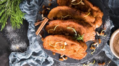 Traditional Christmas Rabanadas with lemon zest, raisins, pine nuts and cinnamon. Spanish Torrijas or french toasts close up on the countertop