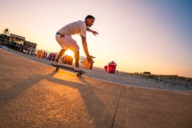 Sörfçü sörf eğitimi gün batımında sahile yakın hareket ediyor..