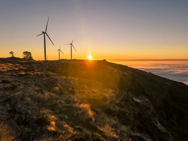 Wind turbines during sunset over a hill in Arouca, Portugal.