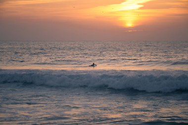 Atlantik Okyanusu 'ndaki sörfçü silueti Furadouro Sahili' nden gün batımı ve altın saat, Ovar - Portekiz.