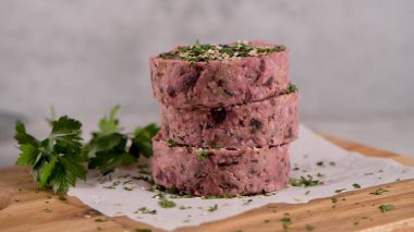 Çiğ vejetaryen burger pancar kökü ve maydanoz yapraklı beyaz fasulye tahta kesme tahtasında..