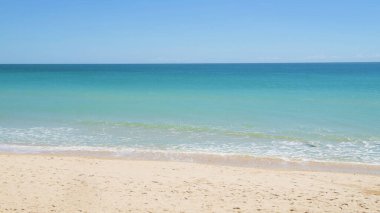 Kumlu sahilde çökmesini yumuşak mavi okyanus dalgaları.