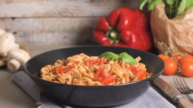 Ton balığı ve fesleğen ile İtalyan makarna. Eski ahşap arka plan üzerinde ton balığı ve domates soslu makarna.