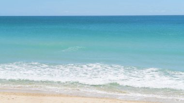 Kumlu sahilde çökmesini yumuşak mavi okyanus dalgaları.
