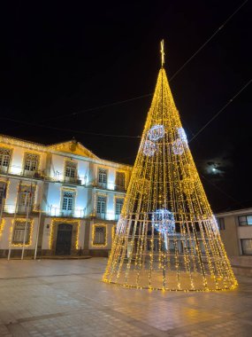 Oliveira de Azemeis, Portekiz - 30 Kasım 2023: Bir yürüyüşçünün Noel ışıklarıyla süslenmiş şehir sokaklarına bakış açısı. Perlim tema parkındaki dekorasyon aynı kalıyor..