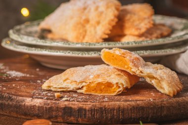 Çıtır hamura sarılmış yumurta ve bademlerden yapılmış hilal şeklinde bir hamur işi. Zanaatkar bir şekilde kesilmiş ve üzerine şeker serpiştirilmiş..