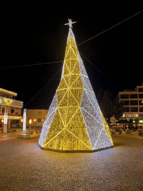 Santa Maria da Feira, Portekiz - Kasım 30 2023: Bir yürüyüşçünün Noel ışıklarıyla süslenmiş şehir sokaklarına bakış açısı. Perlim tema parkındaki dekorasyon aynı kalıyor..