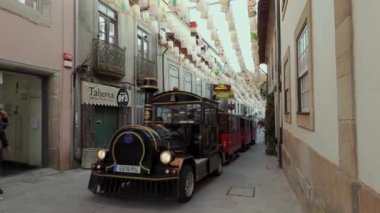 Santa Maria da Feira, Portekiz - 2 Aralık 2023: Bir yürüyüşçünün Noel ışıklarıyla süslenmiş şehir sokaklarına bakış açısı. Perlim tema parkındaki dekorasyon aynı kalıyor..