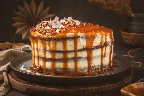 조각의 너트와 코코넛 면도와 맛있는 카라멜 케이크 — 스톡 사진