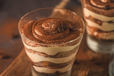 Lezzetli İtalyan tatlı tiramisusu. Koyu bir levhada, taşta ya da betonda bir bardakta..