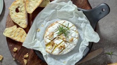 Brie peyniri. Camembert peyniri. Tahta tepside taze dilimlenmiş peynir, fındık, bal ve yapraklarla. İtalyan, Fransız peyniri.