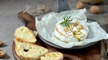 Brie peyniri. Camembert peyniri. Tahta tepside taze dilimlenmiş peynir, fındık, bal ve yapraklarla. İtalyan, Fransız peyniri.