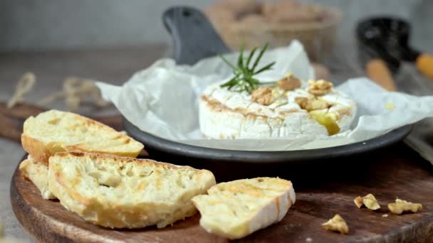 Brie类型的奶酪 Camembert奶酪 新鲜切碎的布里奶酪放在有坚果 蜂蜜和叶子的木制托盘上 意大利语 法语奶酪 — 图库视频影像