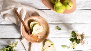 Ahşap masada bal ve fındık ile lezzetli armut.