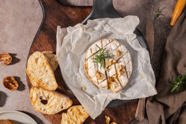 Brie peyniri. Camembert peyniri. Tahta tepside taze dilimlenmiş peynir, fındık, bal ve yapraklarla. İtalyan, Fransız peyniri.