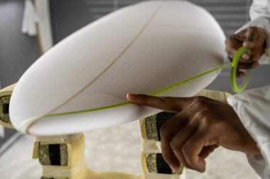 Sörf tahtası imalatı, sörf tahtası ayrıntıları üzerinde çalışan şekillendirici. Endüstriyel imalat, nitelikli profesyonel, mesleki ve istihdam kavramı.