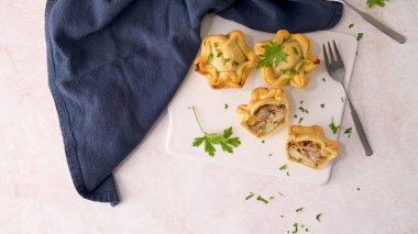 Tavuklu turtalar ve maydanoz yaprakları mutfak tezgahında beyaz seramik tabaklarda.