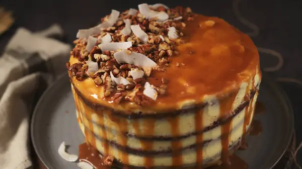 조각의 너트와 코코넛 면도와 맛있는 카라멜 케이크 — 스톡 사진