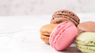 Fransa gelen macarons Bademli kurabiye kurabiye tatlı bir beyaz mermer tezgah üzerinde izole.