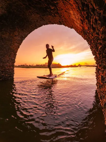 Tragflügelfahrer Gleitet Bei Sonnenuntergang Mit Seinem Board Über Das Wasser Stockfoto