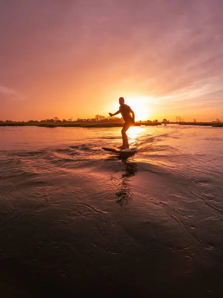 Tragflügelfahrer Gleitet Bei Sonnenuntergang Mit Seinem Board Über Das Wasser Stockbild