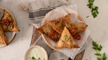 Hint samosaları - kızarmış ya da fırında hamur tatlısı ve baharatlı mutfak tezgahında areca yaprağı tabağında servis edilen lezzetli Hint yemekleri..