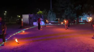 Ovar, Portekiz - 28 Temmuz 2024: Çeşitli milletlerden hokkabazlar geceleri ateşle alıştırma yapıyorlar.