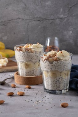 Muz dilimleri ve bademlerle kaplanmış gece gözlüklü yulaflar..