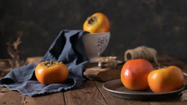 Kaba ahşap elementlerle donanma kumaşında yetişmiş hurma ağaçları hoş bir sonbahar manzarası yaratır. Yumuşak ışıklandırma meyvenin canlı rengini ve dokusunu vurgular.