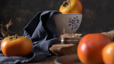 Kaba ahşap elementlerle donanma kumaşında yetişmiş hurma ağaçları hoş bir sonbahar manzarası yaratır. Yumuşak ışıklandırma meyvenin canlı rengini ve dokusunu vurgular.