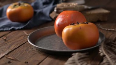 Kaba ahşap elementlerle donanma kumaşında yetişmiş hurma ağaçları hoş bir sonbahar manzarası yaratır. Yumuşak ışıklandırma meyvenin canlı rengini ve dokusunu vurgular.