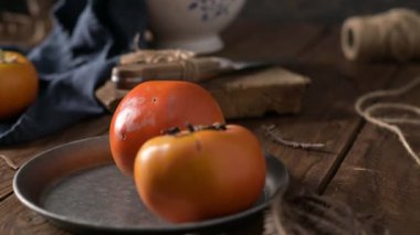Kaba ahşap elementlerle donanma kumaşında yetişmiş hurma ağaçları hoş bir sonbahar manzarası yaratır. Yumuşak ışıklandırma meyvenin canlı rengini ve dokusunu vurgular.