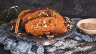 Traditional Christmas Rabanadas with lemon zest, raisins, pine nuts and cinnamon. Spanish Torrijas or french toasts close up on the countertop
