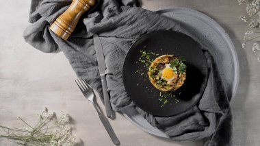 Yanında soğan ve mantarla çevrili kızarmış yumurta ile kıtır kıtır patatesler..