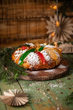 Renkli şekerli meyvelerle süslenmiş pudra şekeriyle tozlanmış ve paylaşılmaya hazır bir Kral Pastası..