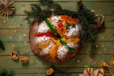 Renkli şekerli meyvelerle süslenmiş pudra şekeriyle tozlanmış ve paylaşılmaya hazır bir Kral Pastası..