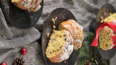 Bolo Rainha dilimleri, fındıklı ve kuru meyveli geleneksel Portekiz Noel pastası, siyah tabaklar üzerinde güzelce sunuluyor.