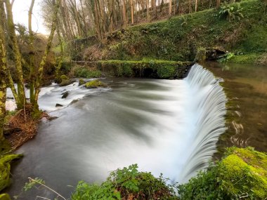 Su, Cascata do Outeiro yakınlarında büyüleyici bir manzara yaratarak taştan bir su birikintisinin üzerine taşar. Uzun pozlama suyun hareketini yakalar ve Oliveira de Azemeis 'te bir huzur hissi yaratır..