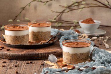 Lezzetli tiramisu esinlenilmiş chia pudinginin tadını çıkarın, kremalı kahve serpiştirilmiş chia katmanları ve bozuk çikolata sosu. Bu suçsuz kahvaltı ya da tatlı klasik lezzetlerle sağlıklı ve tatmin edici maddeleri harmanlıyor.