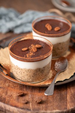 Indulge in a luscious tiramisu-inspired chia pudding, layered with creamy coffee-infused chia and a rich chocolate topping. This delightful breakfast or dessert option combines classic tiramisu flavors with wholesome ingredients for a convenient and  clipart